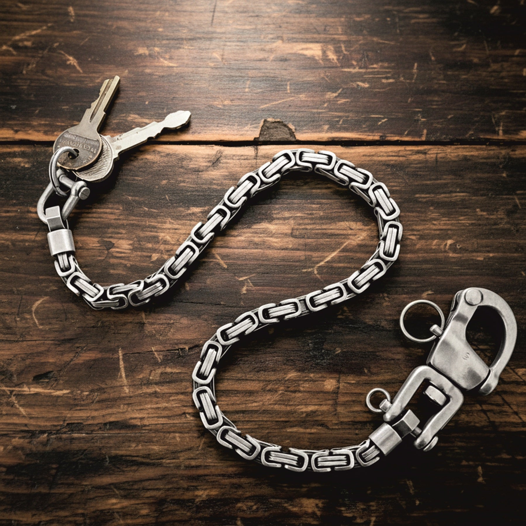 Massive Edelstahl Schlüsselkette in Königsketten-Design mit Karabiner und Schlüsseln auf Holzuntergrund
