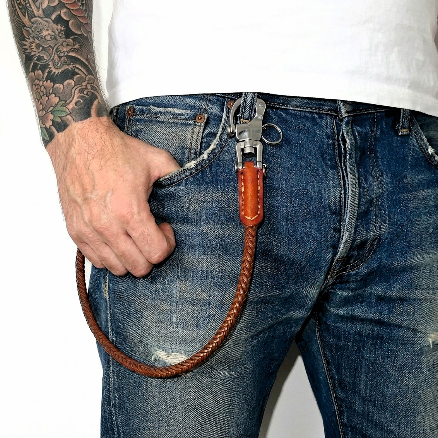 Braune Leder Hosenkette aus geflochtenem Echtleder an Jeans getragen mit Edelstahl-Karabiner und Wallet Chain Style.