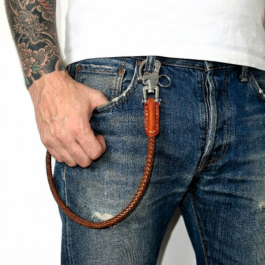 Braune Leder Hosenkette aus geflochtenem Echtleder an Jeans getragen mit Edelstahl-Karabiner und Wallet Chain Style.
