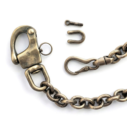 Detailansicht einer Wallet Chain im Vintage-Look mit massiven Karabinern, Ankerkette und messingfarbener Oberfläche